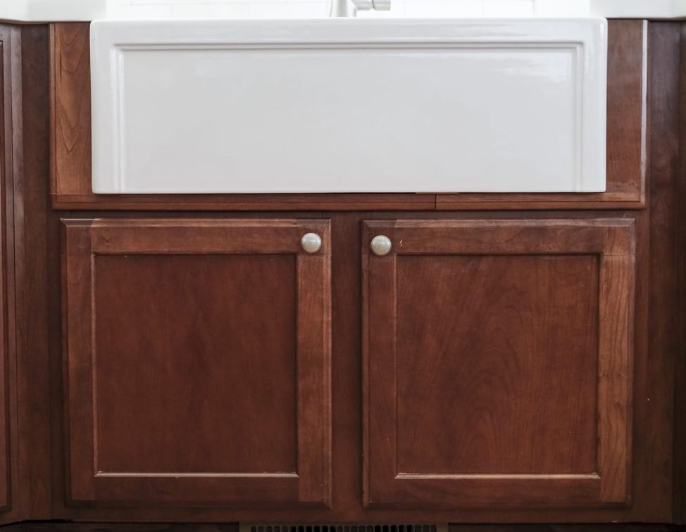 the front view of a white fireclay kitchen sink in a standard kitchen