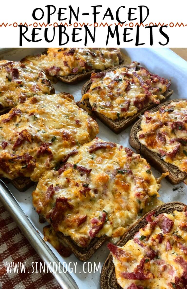 A baking sheet with several open-faced Reuben melts topped with melted cheese and corned beef, with the text "Open-Faced Reuben Melts" and "www.sinkology.com" displayed above and below the image.