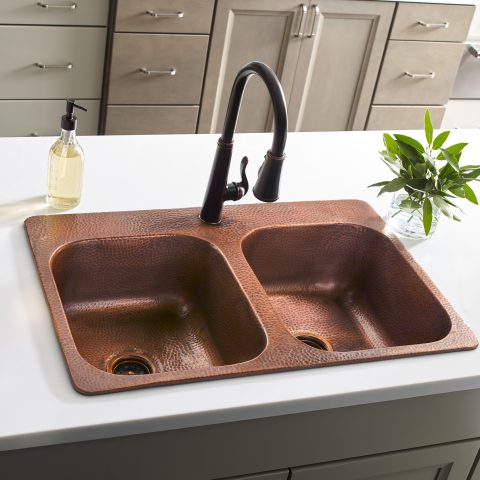 A copper rectangular drop-in double basin sink in a modern farmhouse kitchen.