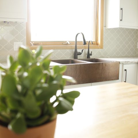 A copper rectangular undermount double basin farmhouse sink in a modern farmhouse kitchen.