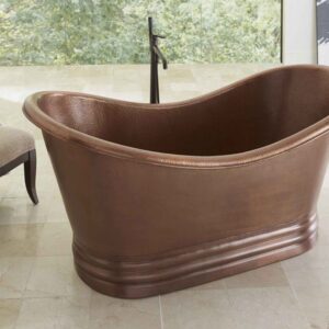 Euclid copper freestanding tub in large bathroom with window with view of greenery outside.