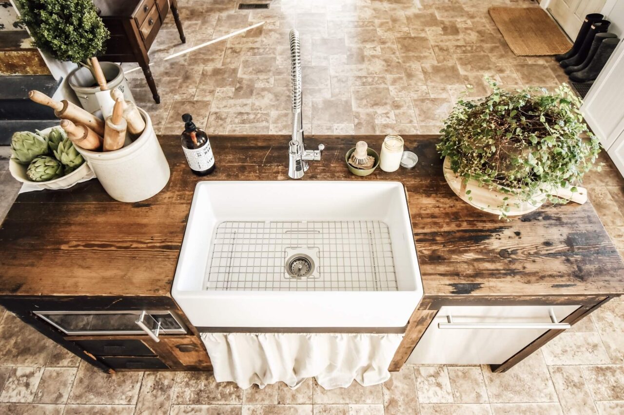 A farmhouse kitchen sink with a wooden countertop.