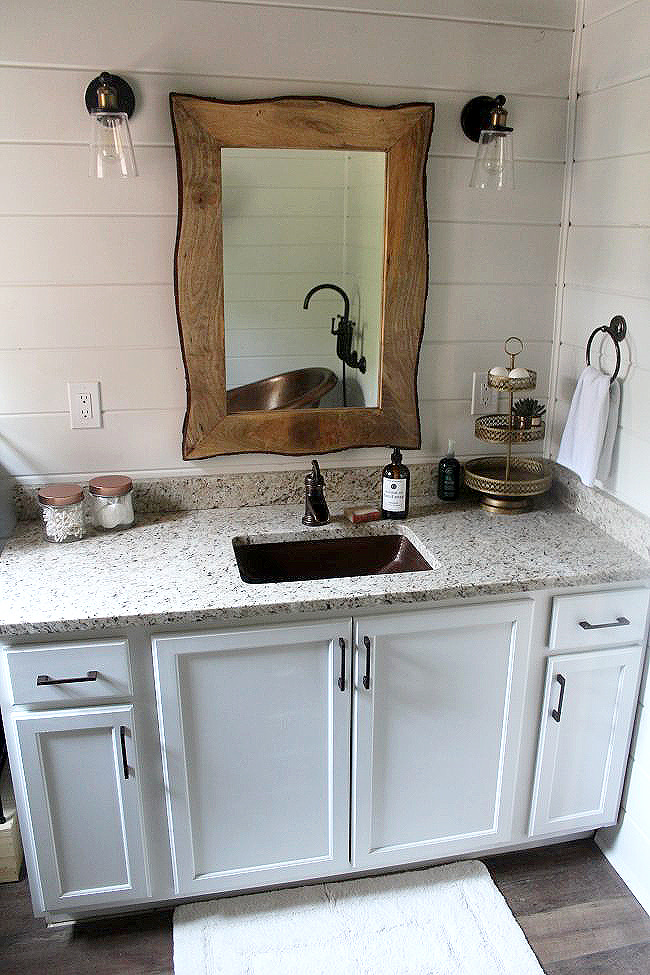 a bathroom vanity with a copper sink
